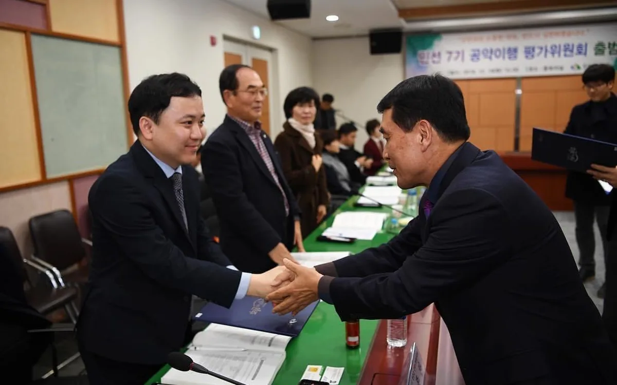 완주군 공약이행 평가위원회 출범식에서 위촉장을 받고 악수하는 장면